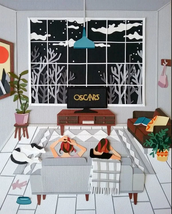 paper cut scene of young women on couch watching the Oscars on TV