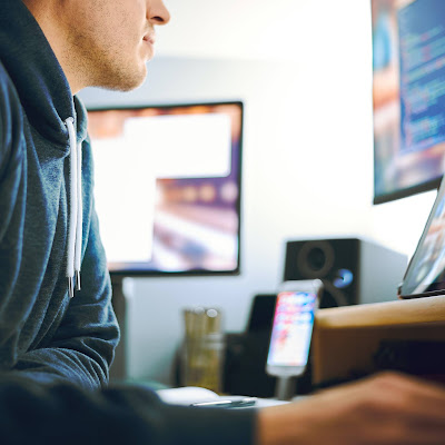 Hombre trabajando con más de un monitor