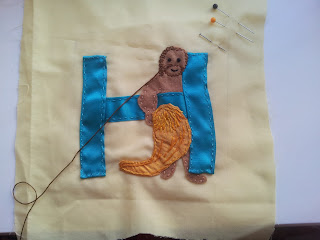Letter H - most parts sewn down, working on stitching the hair in a second darker colour to make it more clear