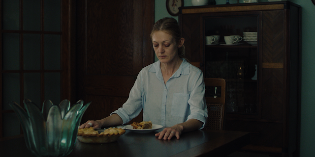 Holly sits at table eating pie