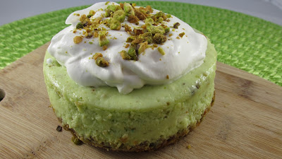 4 inch pistachio cheesecake on a crust with pistachio and homemade whipped cream then topped with more pistachios