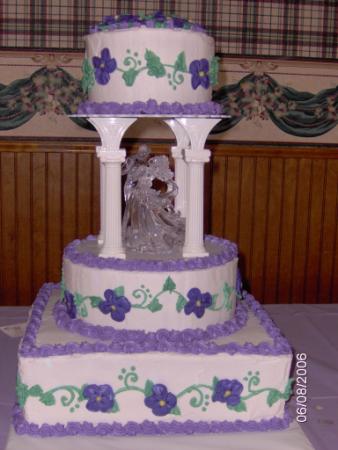 Elegant three tier square white wedding cake with green icing leaf patterns