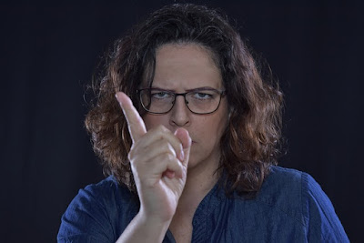angry woman wearing spectacles shows finger