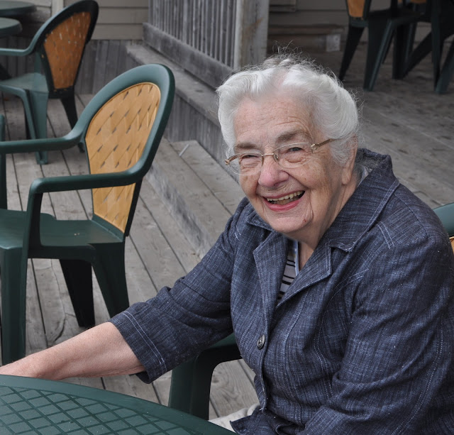 Grandmother smiling sitting at a table outside