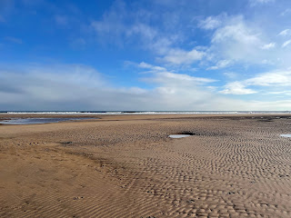 A sandy beach under blue skies.