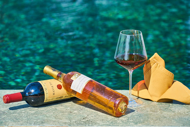 https://www.pexels.com/photo/two-labeled-bottles-of-wine-beside-a-wine-glass-by-the-pool-3019019/