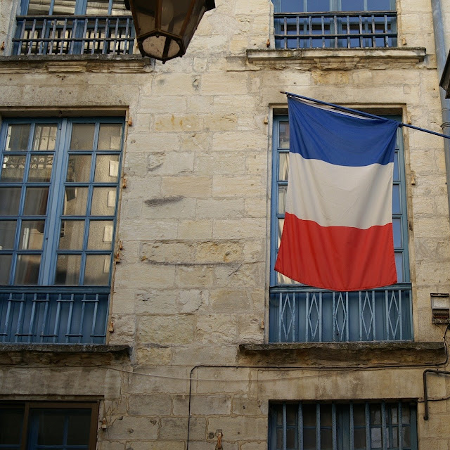 french flag and old building