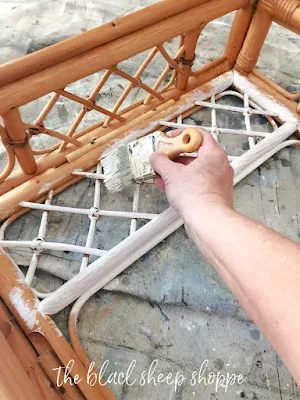 Using a sash brush to paint the underside of a rattan table.