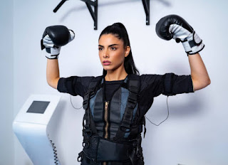femme portant equipements d'electrostimulation et gants de boxe