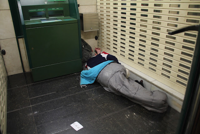 Una persona durmiendo en un cajero de un banco