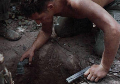 Tentara AS memeriksa lubang Viet cong