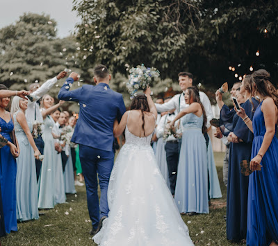 Novios saliendo de la ceremonia con los invitados haciéndoles un pasillo y lanzándoles confetti