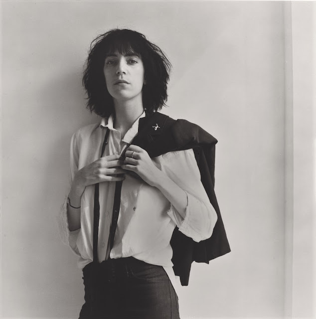 O retrato mostra a cantora e poetisa Patti Smith, companheira de Robert Mapplethorpe durante anos, de pé diante de uma parede branca onde projeta-se um sutil triângulo de luz. Smith encara a câmera com semblante sóbrio. Traz a mão direita ao peito e a esquerda segura o paletó preto jogado por cima do ombro esquerdo.  Sua vestimenta,  camisa branca, calça preta e gravata preta desatada, assim como o corte de cabelo desgrenhado resultam em um visual andrógino. Trata-se da foto de capa do álbum Horses, o primeiro da carreira de Smith. O minúsculo cavalo prateado que enfeita o paletó faz referência ao nome do disco, uma vez que Horses significa cavalo em inglês. 