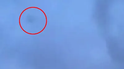Black Silhouette UFO Sphere inside of a cloud.