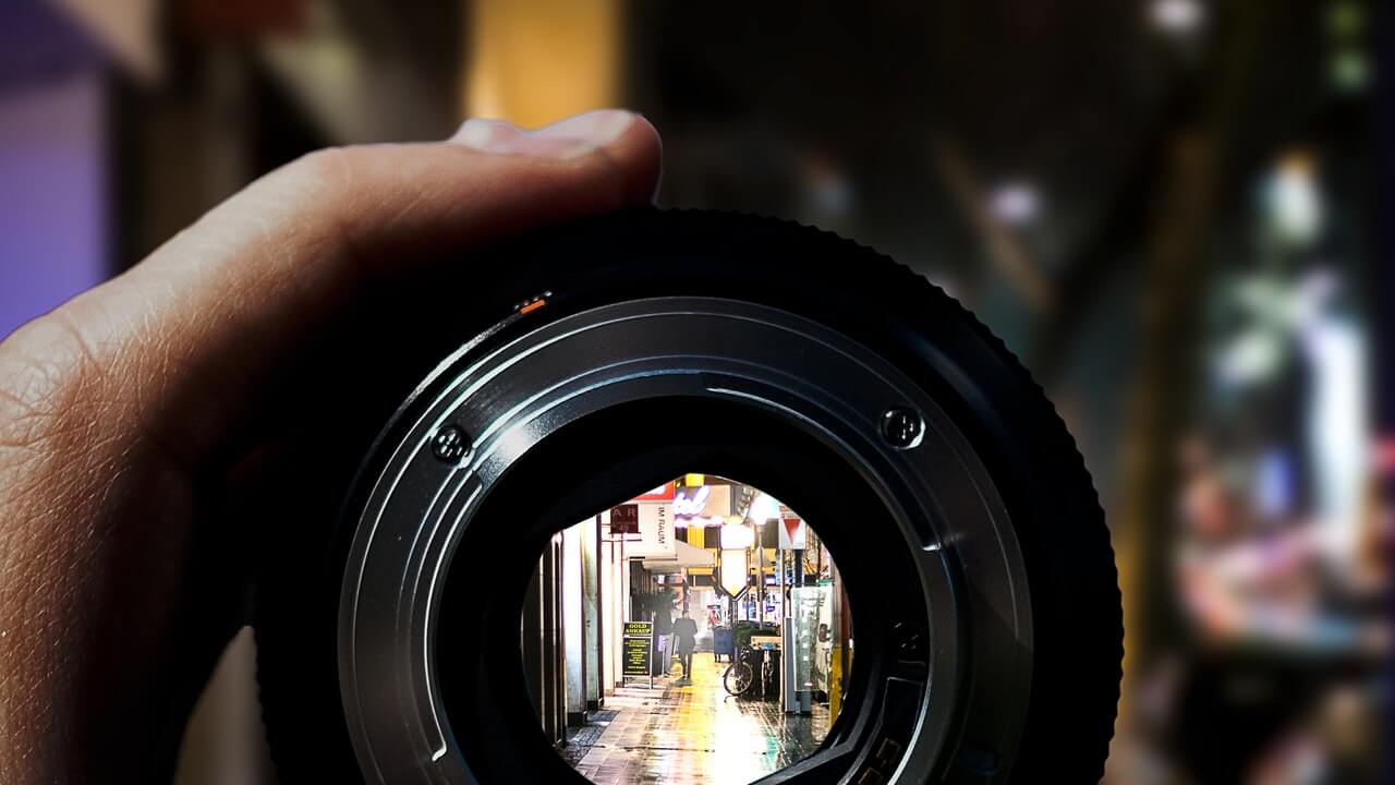 camera lens zoom on man walking on a street | 10 Product Photography Tips