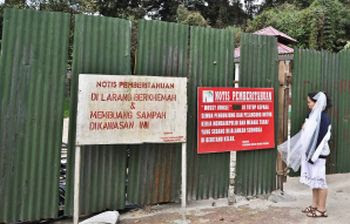 No entry: Tay Sim Yee, 32, looking at a couple of notice boards at the entrance to the Mossy Forest boardwalk in Cameron Highlands.