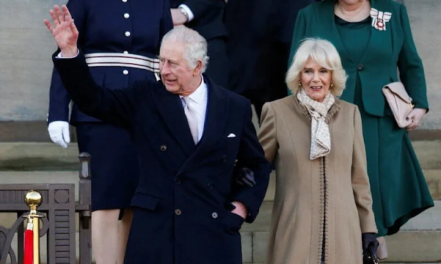 Queen Camilla wore a beige midi coat and floral print dress. Beige suede boots. The Norbrook Community Centre in Wythenshawe