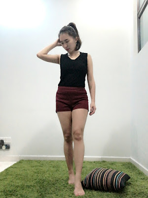 She stands on the IKEA Hampen Greeny Carpet with the pose showing her black top and wine red shorts for the day of outing.