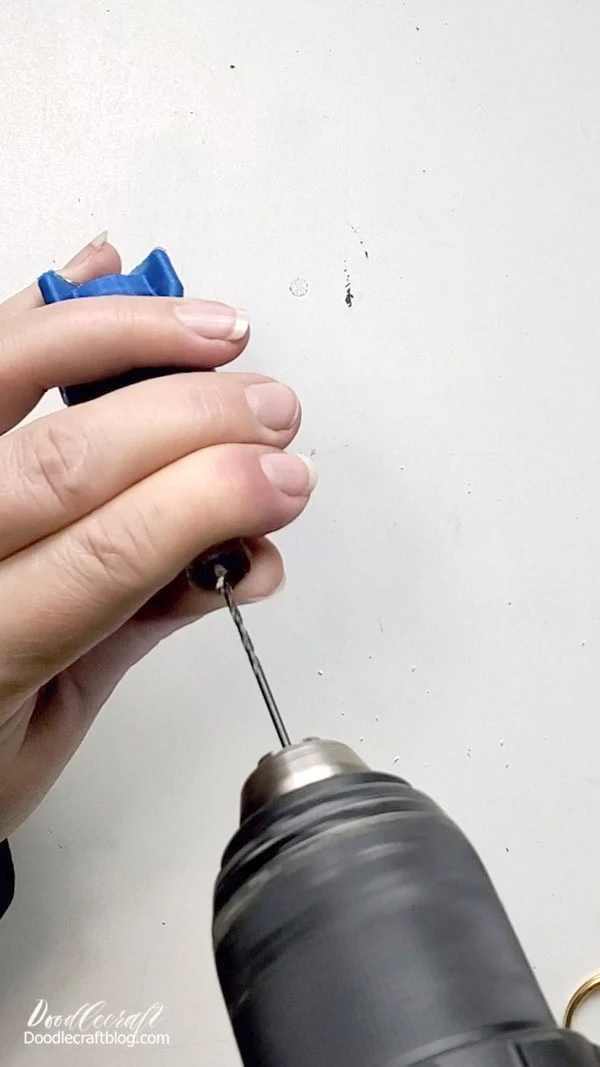 Use a drill and small drill bit (the same width as the screw eyes) and drill a small hole in the top of the nuka quantum bottle.