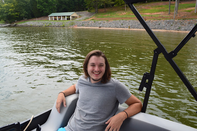 Andy smiling while sitting on the back of the boat.