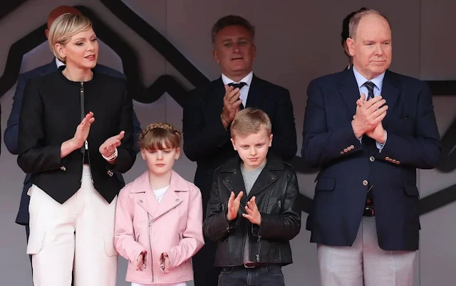 Princess Charlene wore a black zipped jacket by Akris. Princess Gabriella wore a zipped biker pink jacket by Polo Ralph Lauren