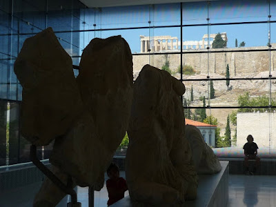 Réplicas de los mármoles del Partenón en el Museo de la Acrópolis de Atenas, con el propio Partenón al fondo de la imagen