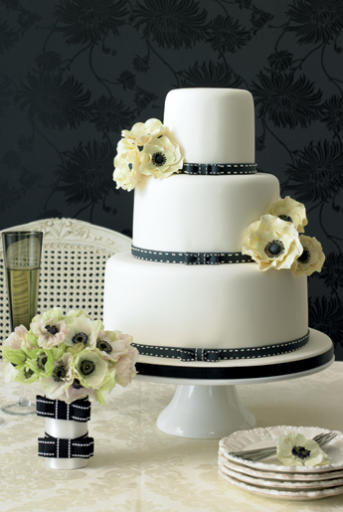 Elegantly romantic 3 tier wedding cake with white frosting black ribbon 