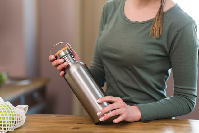 close-up-woman-holding-coffee-thermos_23-2148454522.jpg
