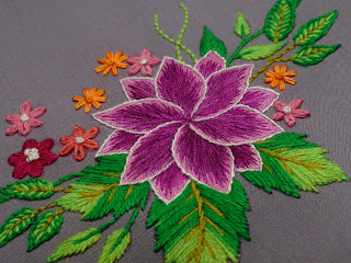 Hand-embroidered flower design with green leaves