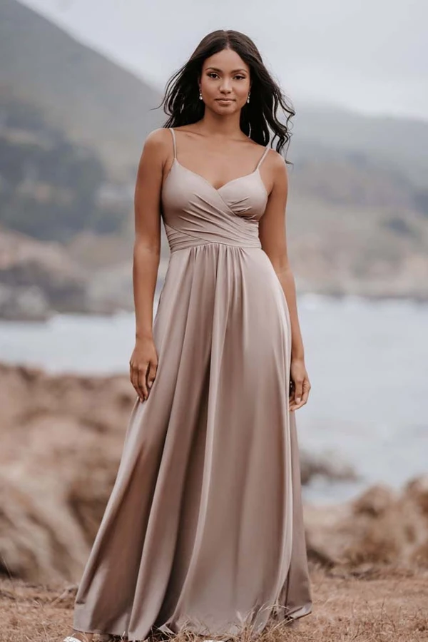 a beautiful bridesmaid in a beige minimalist dress posing for the camera