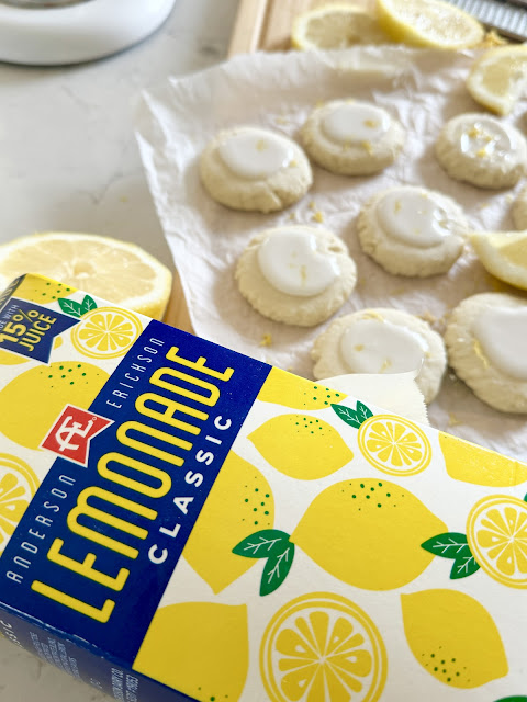 AE Dairy Lemonade carton in front of lemon meltaway cookies on parchment paper.