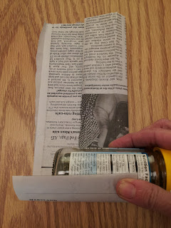 newspaper rolled around spice jar