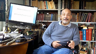 Professor Carlos Ramalhete sentado e segurando um cachimbo.