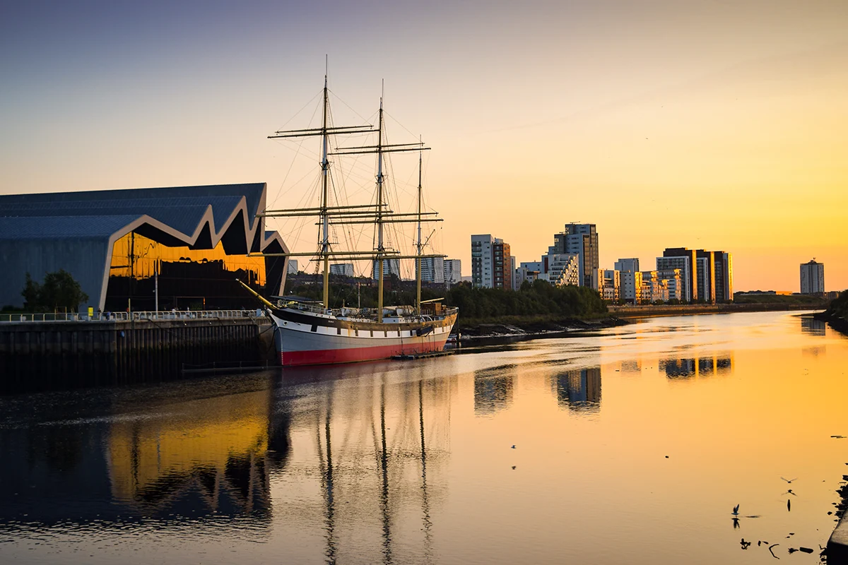 a boat in the sunset on the river clyde