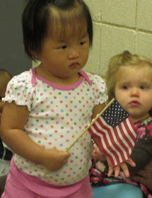 photo of: Toddlers wave the American Flag during Author Visit with Debbie Clement
