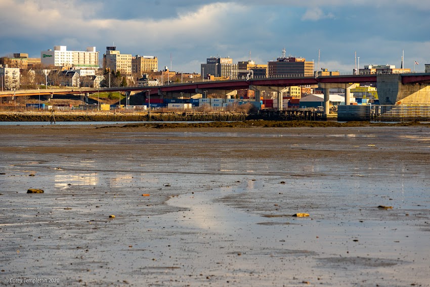 Portland, Maine USA April 2020 photo by Corey Templeton. Clearing clouds above the Portland skyline at low tide.