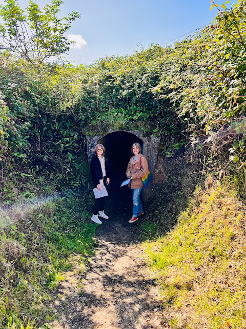 Teenagers standing at entrance to bunker at Maisy Battery, France