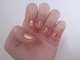 white hand with really short nails painted in gold glitter