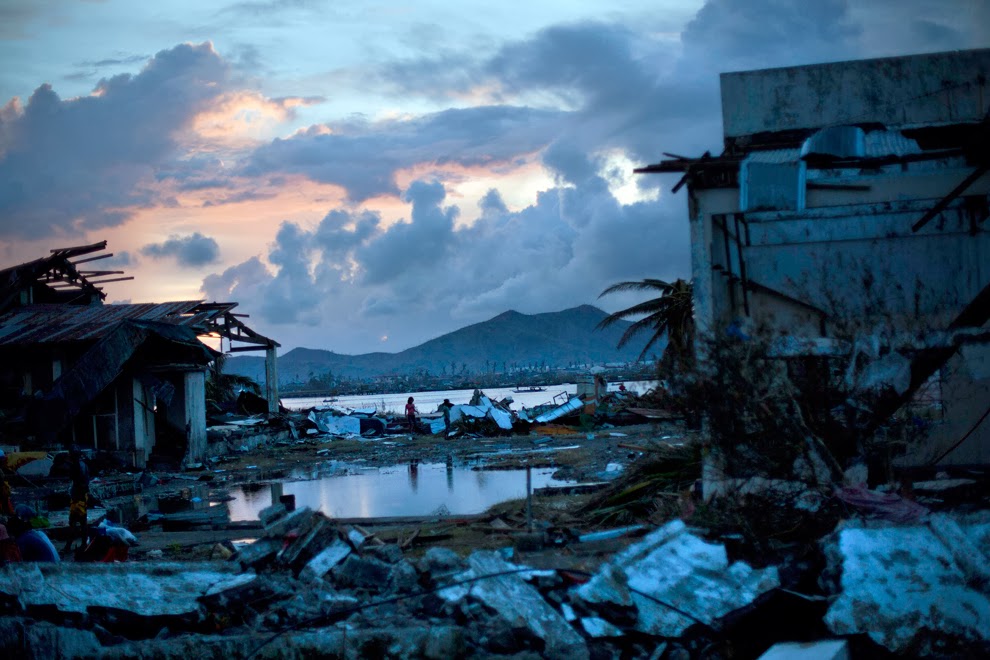 Typhoon Haiyan survivors walk through the ruins of their neighborhood on the outskirts of Tacloban, central Philippines on Nov. 13. (David Guttenfelder/Associated Press) #