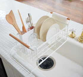 dish rack that rests over the sides of the sink, with the rack rising up  above the sink