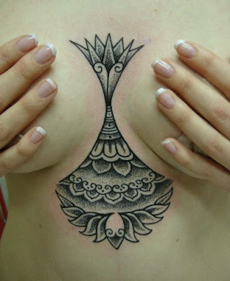 Comments: This is a fresh tattoo done between the breasts using the dot