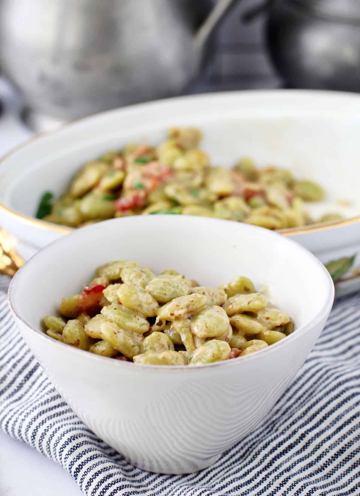 Creamed Lima Beans with Bacon in a small bowl in front of a casserole dish.