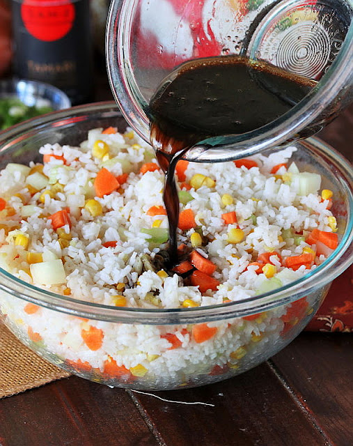 Pouring Soy Sauce Mixture Over Rice in Mixing Bowl Image