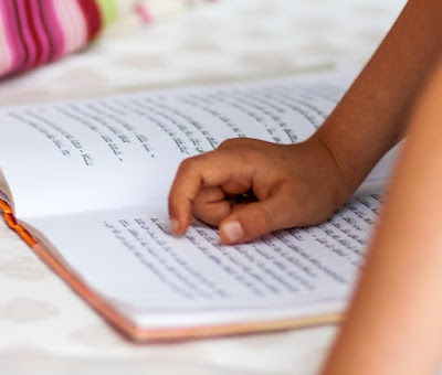 Child reading from a Hebrew book (Credit: Lavi Perchik/Unsplash)