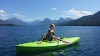 Girl looking at the mountains in her green kayak