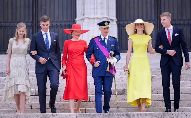 Princess Eleonore wore a ruffled midi dress by Maje. Princess Elisabeth wore a yellow dress. Queen Mathilde wore a red dress