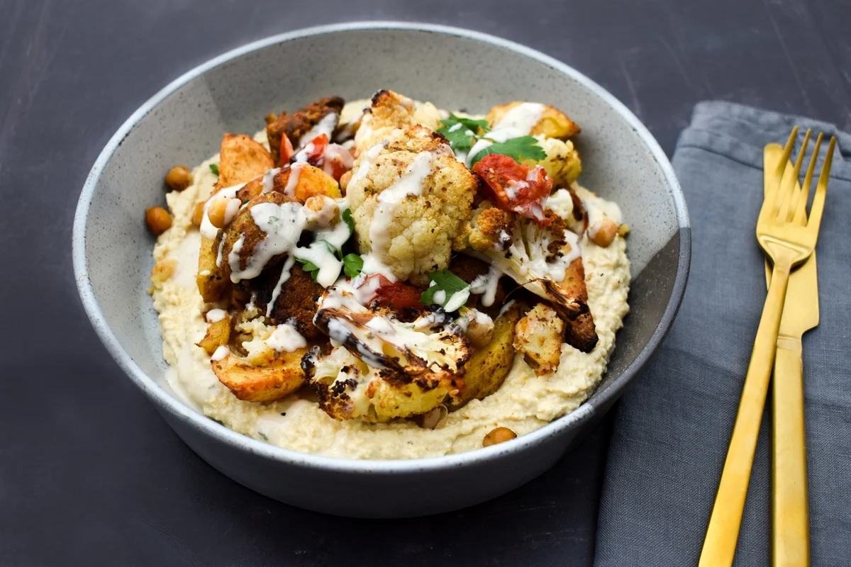 Middle Eastern Cauliflower Bake served in a bowl with hummus.