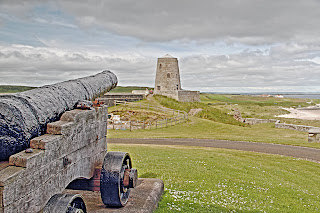 Bamburgh Castle Canon pointed at an old windmill