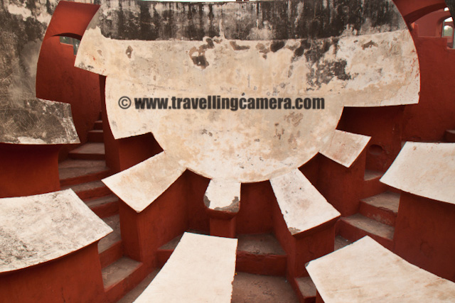 A Quick visit to Jantar Mantar in Capital City of India - Delhi : Posted by VJ SHARMA on www.travellingcamera.com : The Yantra Mantra which literally means 'instrument and formula' and often called as Jantar Mantar... There are multiple Jantar Mantars in India and Delhi has also one near Connaught Place.... Jantar Mantar in Delhi consists of 13 architectural astronomy instruments which were built by Maharaja Jai Singh 2 of Jaipur... Some of my friends decided to meet on weekend at CP but few of them were late... We were only two at that time and though of roaming around the place and reached at Jantar Mantar... I have been to Jantar Mantar at Jaipur and the one in Delhi seemed smaller as compared to that... Check out some of the photographs of Jantar Manatar @ Delhi...Here is a photograph of one of the yantra to predict time with respect to the movement of sun and shadows.... Its really amazing work... There are lot of yantras there and each one solves a particular problem.... Sometimes calculations from one are used in conjunction with the calculations from other to draw some more useful conclusions... Its hard to believe that such a great scientific work are available in 17s....Here is the main architectural form which we normally saw in most of the photographs of Jantar Mantar... Most of the times its very crowded and I had to wait for approximately 25 minutes to have these two people walking in front of it... Most of the times 50+ people can be found around this yantra and have some photographs....Ram Yantra at Jantar Mantar, DelhiInitially Jai singh had started building these from Brass but soon they realized some bad impacts of the metal and revisited the though of selecting other construction material... Main purpose of these observatories was to compile astronomical tables and to predict the times, movements of the sun, moon & planets. Some of these purposes nowadays would be classified as astrology... Its one of the main places to visit in Delhi and amazing work which completed in 1724....Indian Policemen doing something in lawns of Jantar Mantar, Delhi, INDIAApart from Delhi, the other Jantar Mantars are there is Jaipur, Varanasi, Ujjain and Mathura....