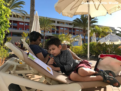 Family on sunloungers by pool